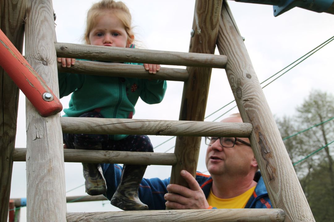 Torsten Strohbach hilft einem Mädchen beim Klettern